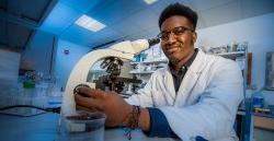 student in laboratory using binocular microscope